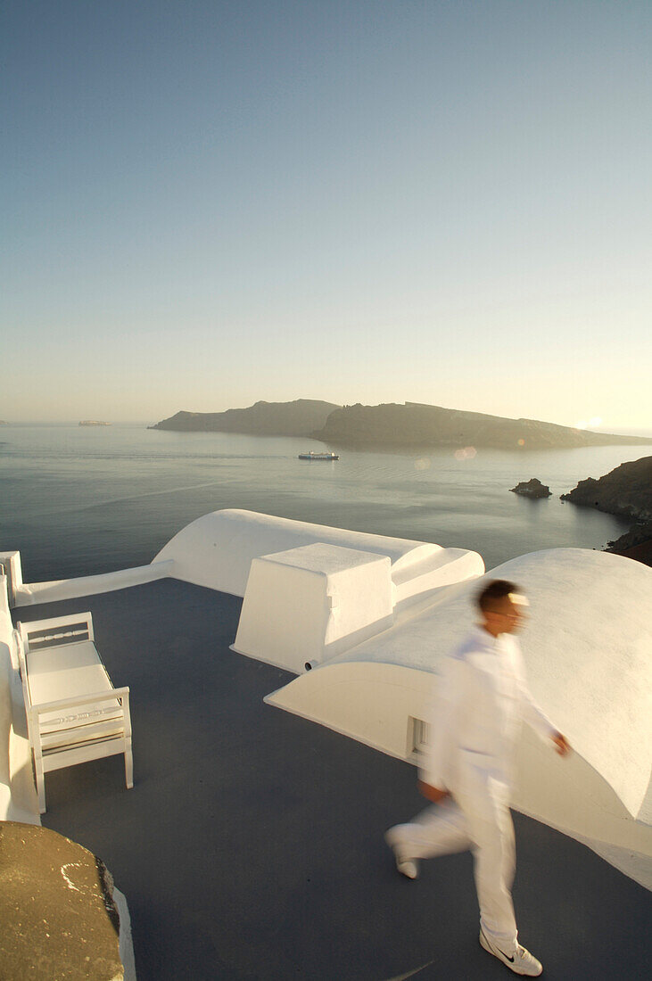 Man in white walking on roof terrace, Katikies, Santorini