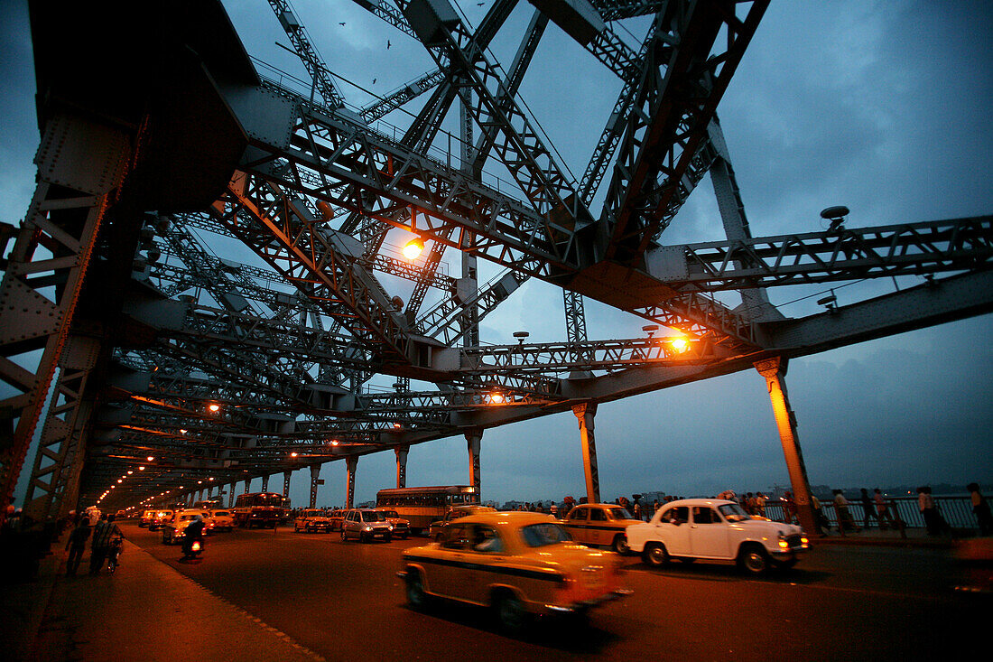 Taxis going over Howra Bridge in Calcutta at dusk, Calcutta, West Bengal, India