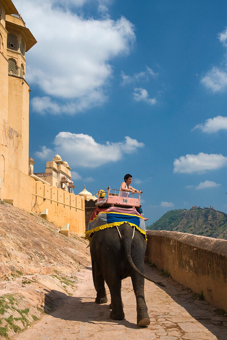 Tourist on elephant going up path at Amber Fort, Near Jaipur, Rajasthan, India