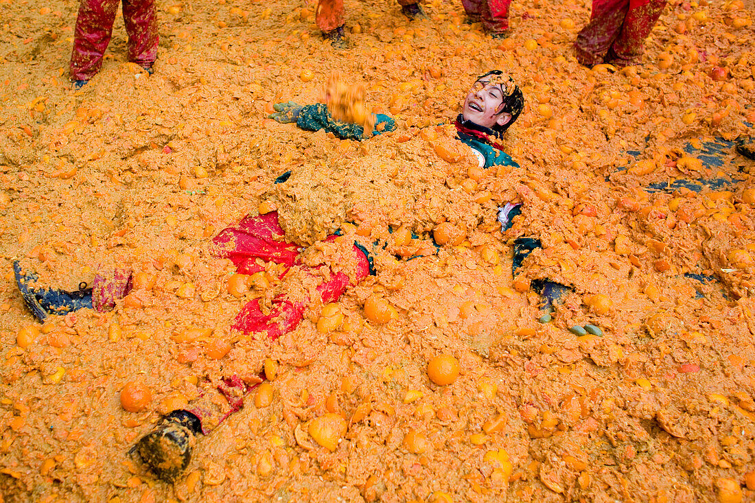 Submerged in oranges at Orange Festival, Ivrea, Italy