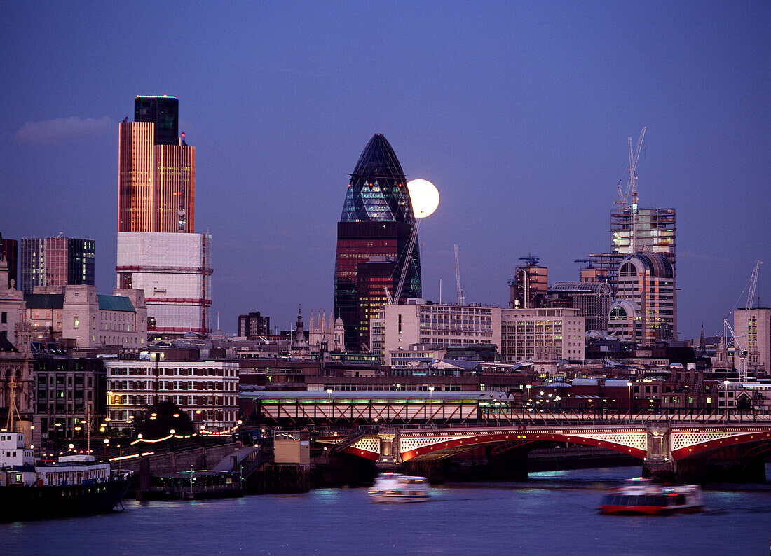 Looking down the Thames at dusk to full moon rising behind the Swiss Re  building, London, England