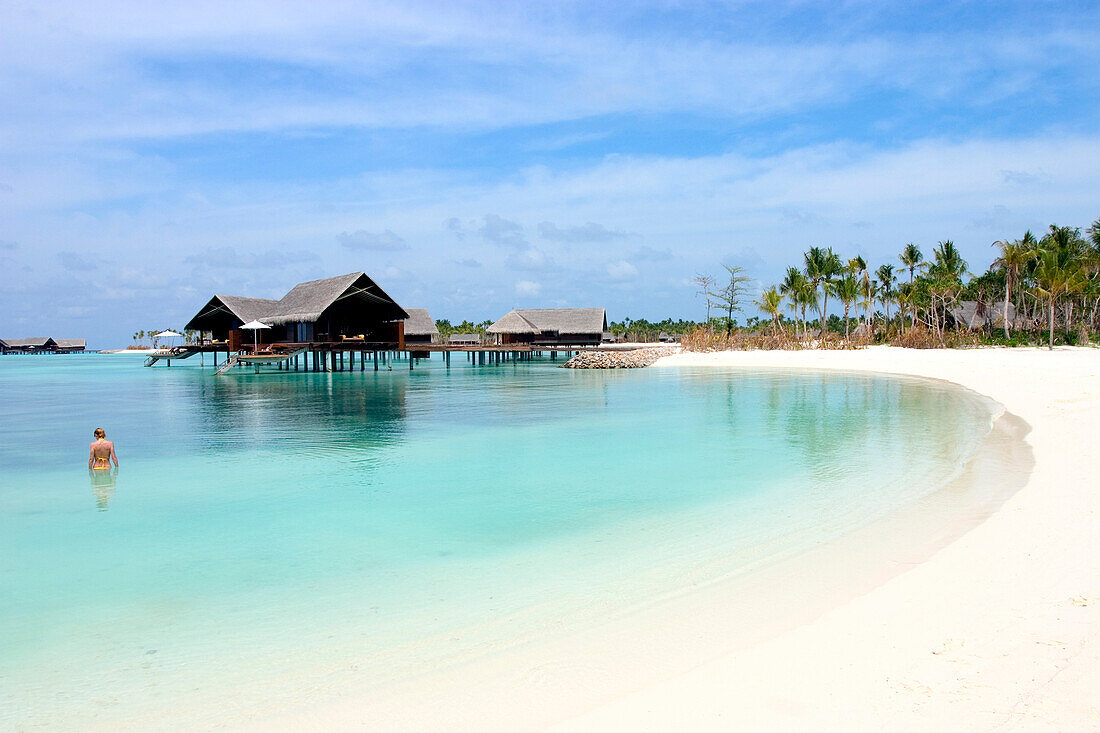 View of bungalos with swimmer, Maldives