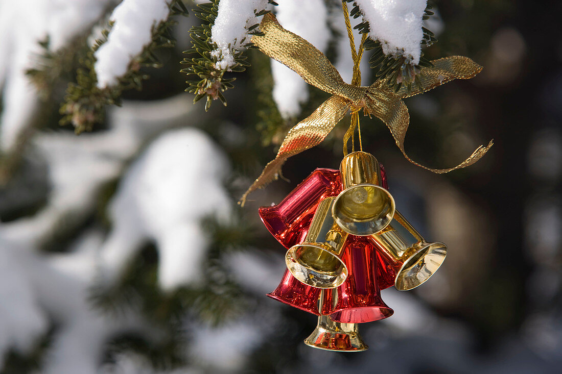 Jingle bells Christmas ornament hanging outside in snow