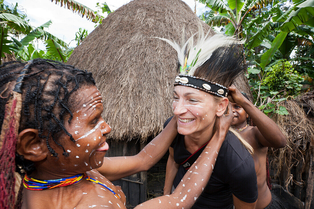 Touristin bei Schweinefest in Dani Dorf, Baliem Valley, West Papua, Indonesien