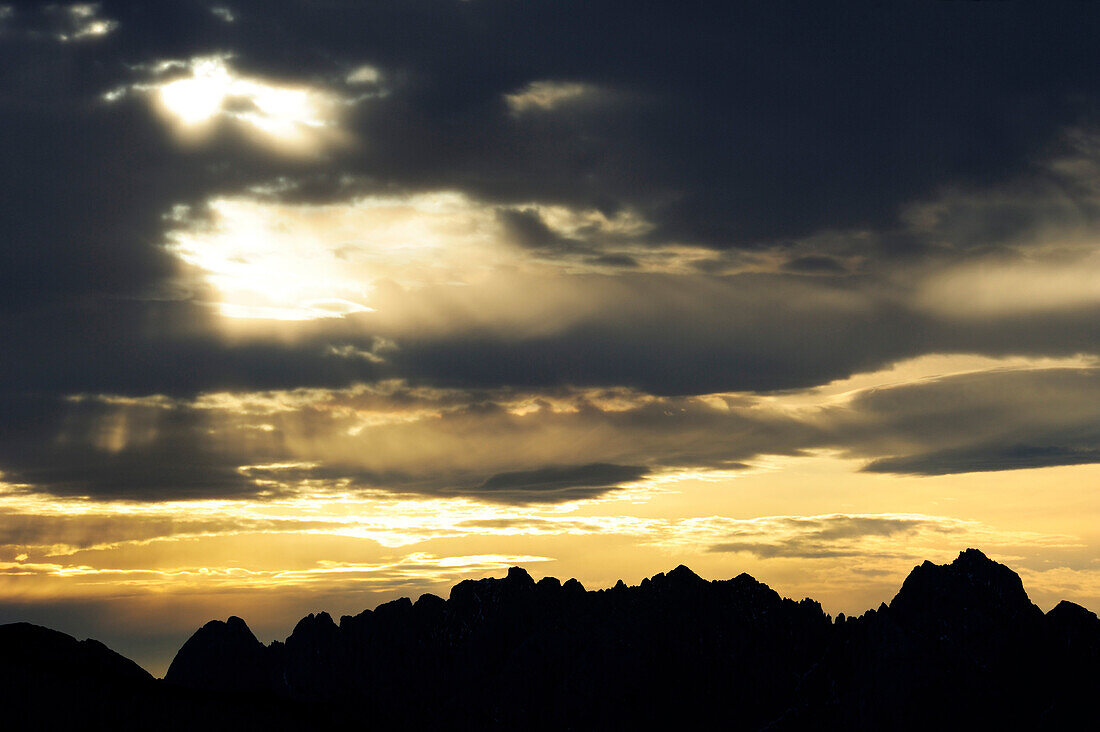 Sonnenstrahlen scheinen durch Wolken, Kaisergebirge als Silhouette darunter, vom Wendelsteingebiet, Bayerische Alpen, Oberbayern, Bayern, Deutschland, Europa