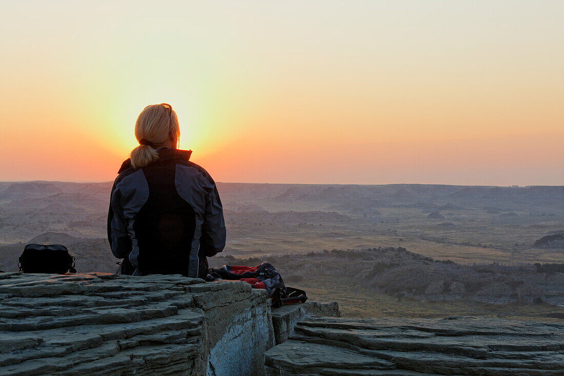 Eine Frau genießt den Sonnenuntrgang, Theodore-Roosevelt-Nationalpark, Medora, North Dakota, USA