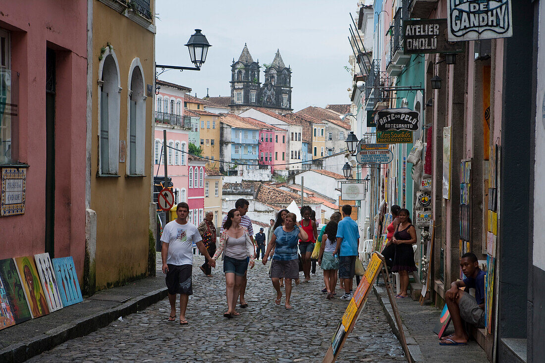 People walk on Pelourinho old town street with Igreja do Santissimo Sacramento do Passo church, Salvador, Bahia, Brazil, South America