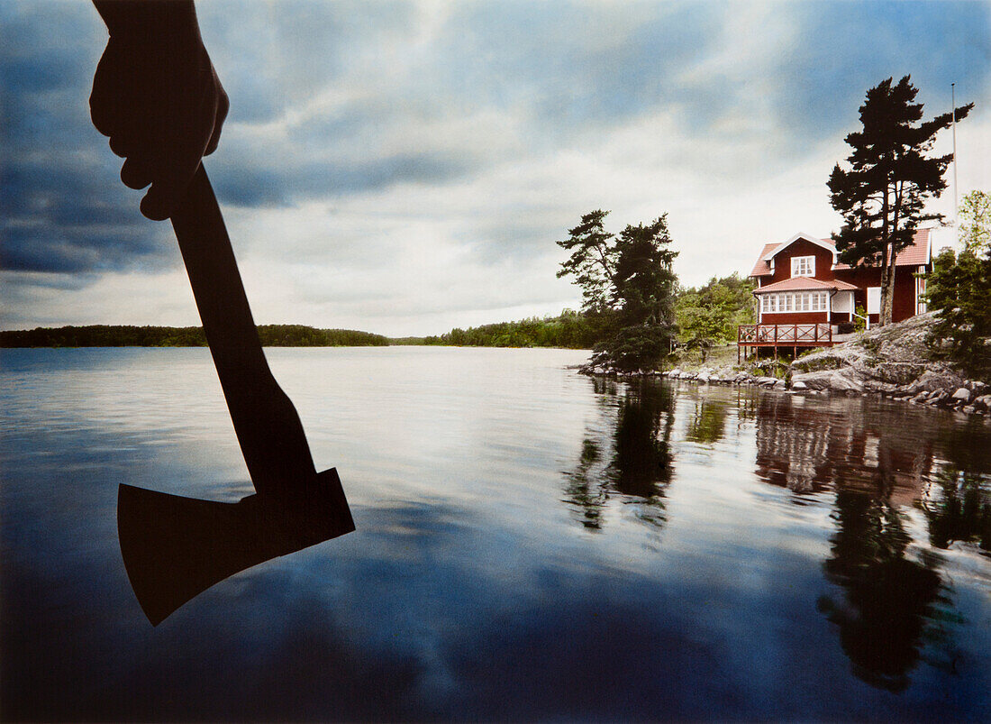 Hand mit Axt, Haus in den Schären bei Stockholm, Schweden, Europa