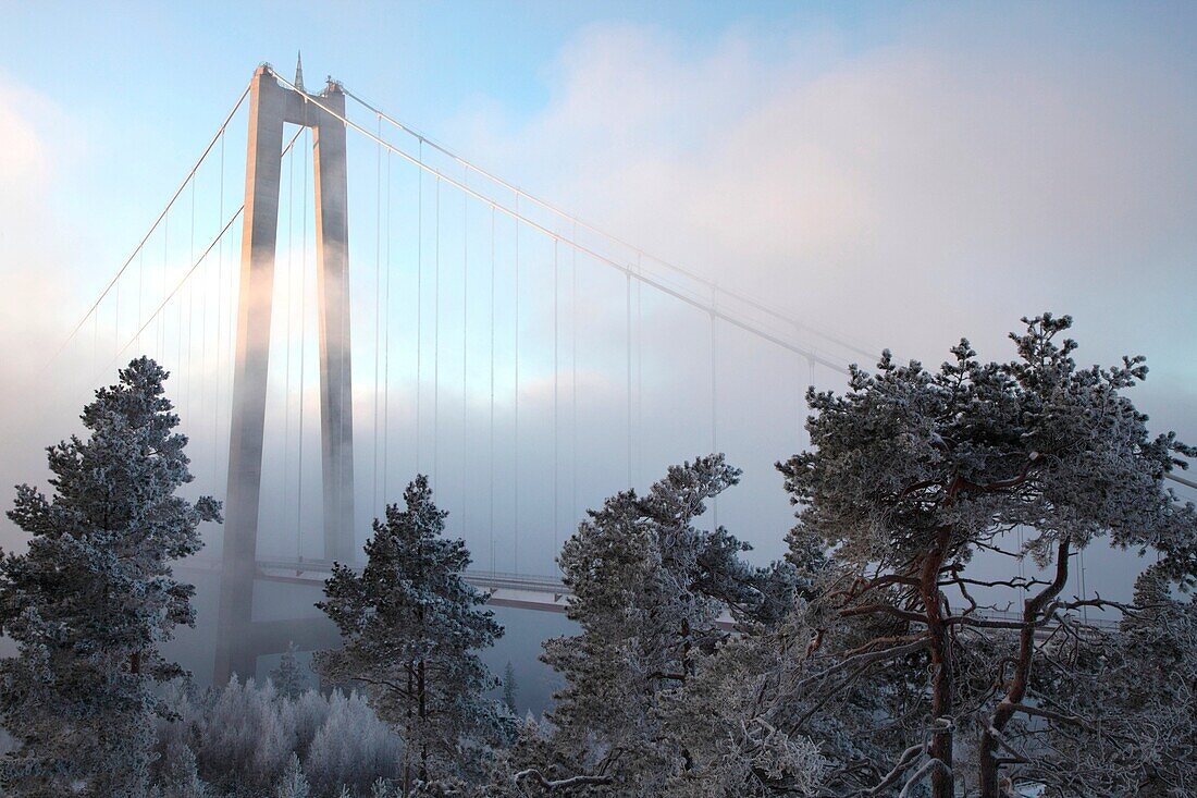 The High-Coast Bridge (Höga-Kusten Bro) on a very cold day in Västernorrland, Sweden. Clouds of steam rise over the freezing river.