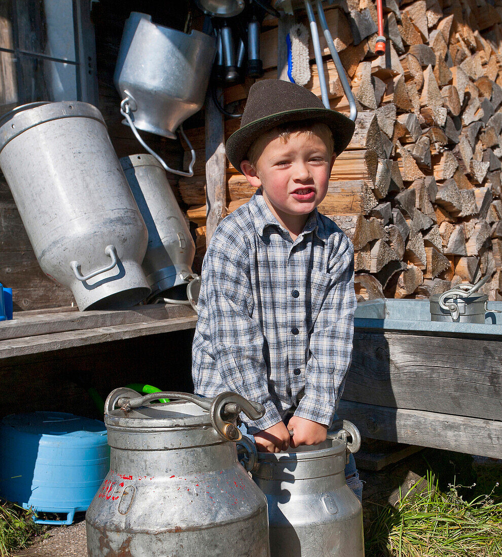 Boy holding a milk churn, Hofbauern-Alm, Kampenwand, Chiemgau, Upper Bavaria, Germany