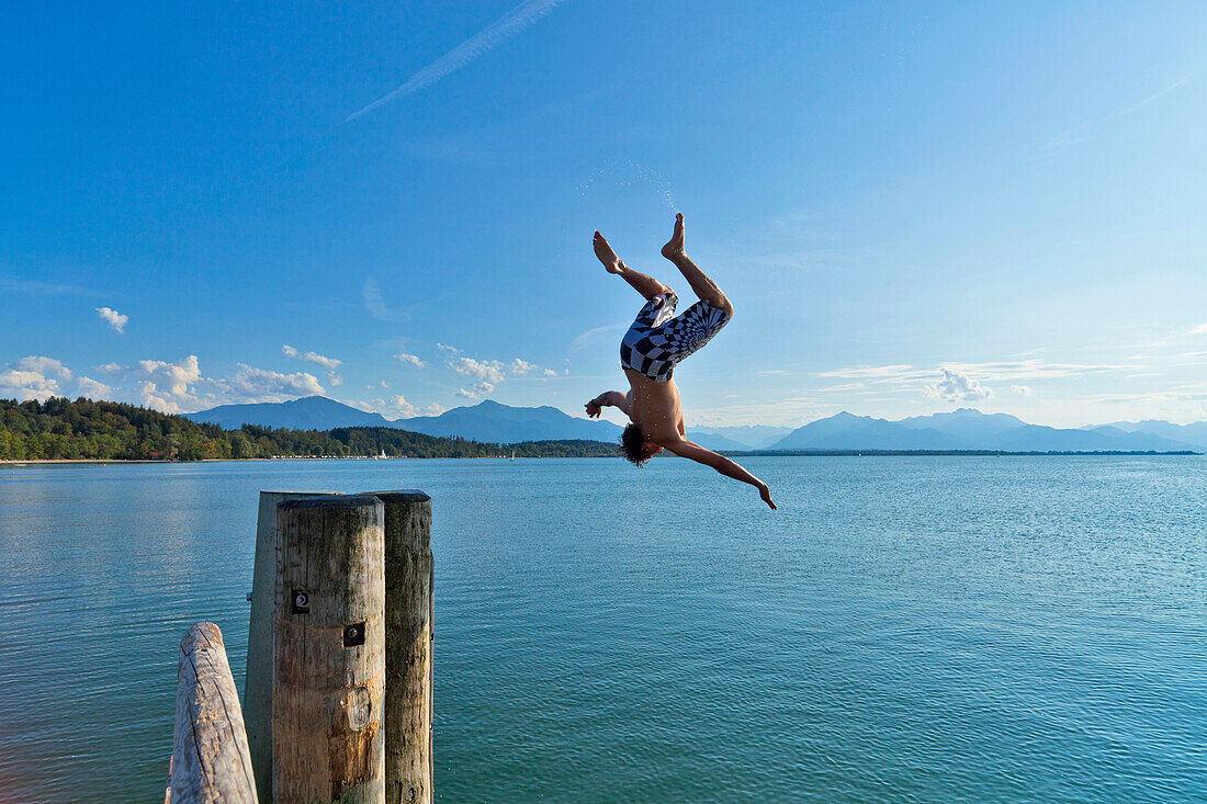 Man doing backflip into water, Chieming, lake Chiemsee, Chiemgau, Upper Bavaria, Germany