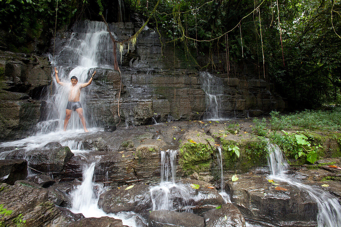 Mann duscht unter Wasserfall bei Cascada de Latas, Amazonas, Ecuador, Südamerika
