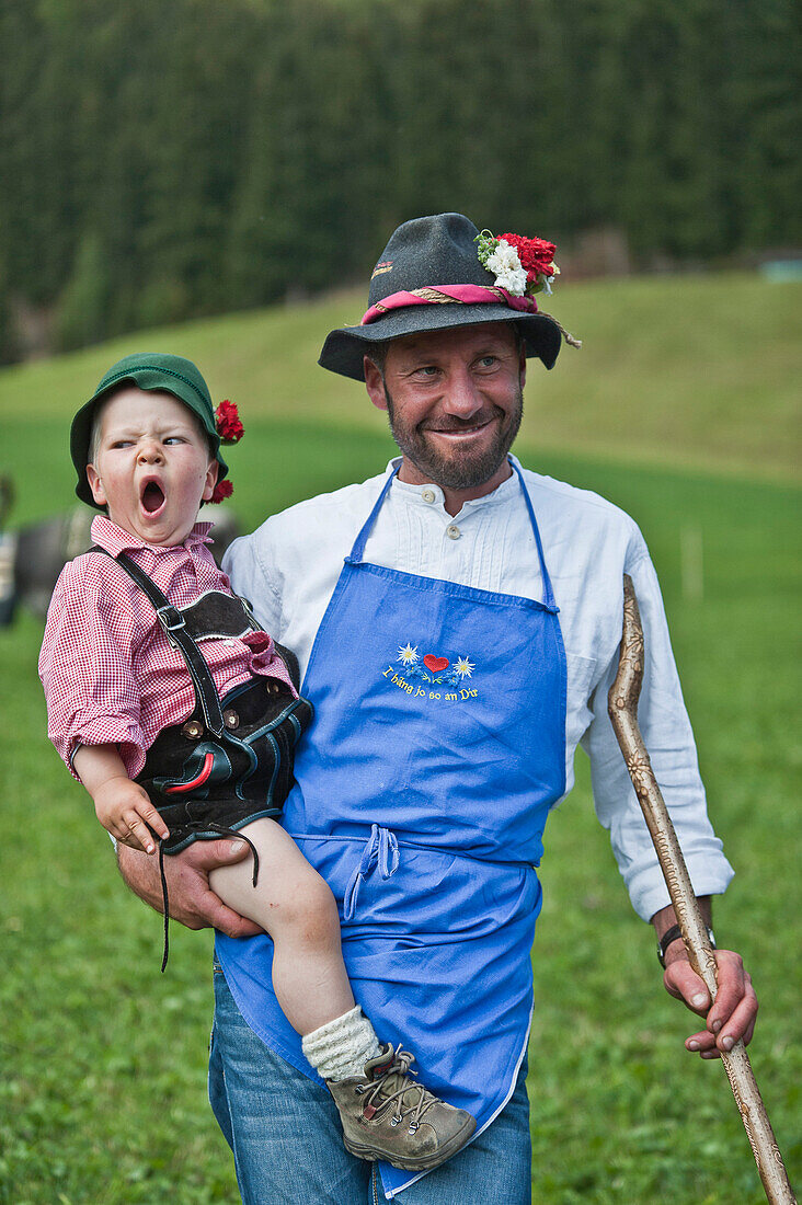 Farmer and son wearing traditional clothes, drive fromthe mountain pastures, Almabtrieb, Ulten valley, South Tyrol, Italy