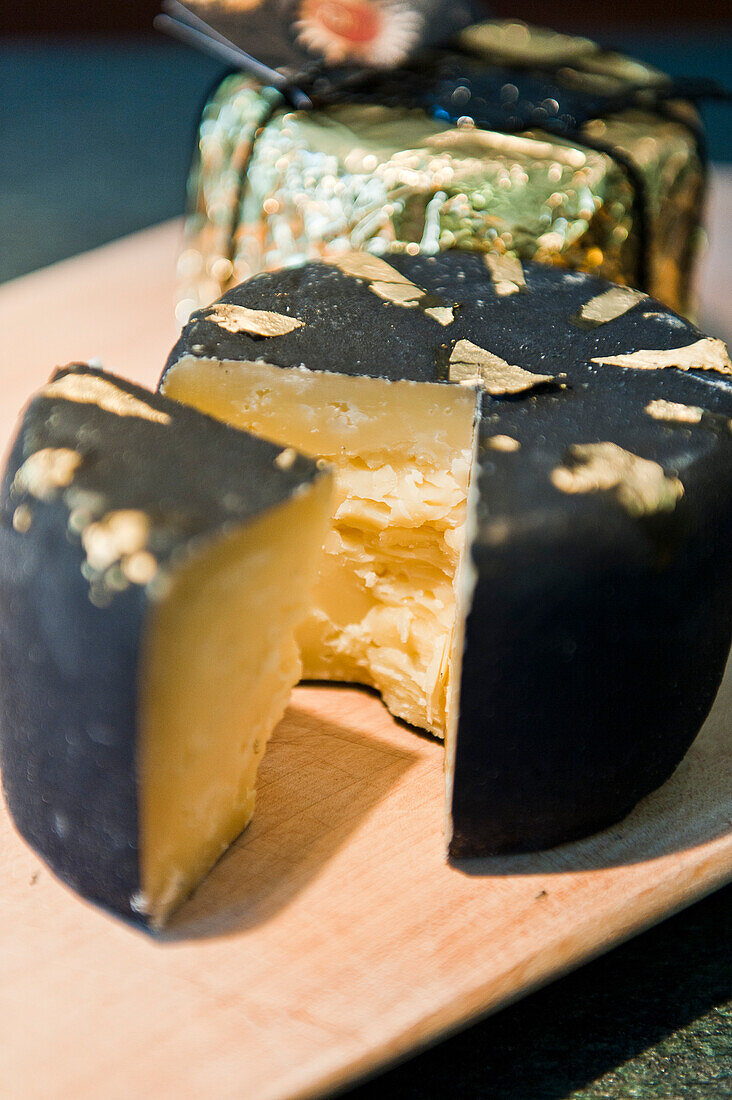 Chunk of cheese with gold leaf, De gust, South Tyrol, Italy