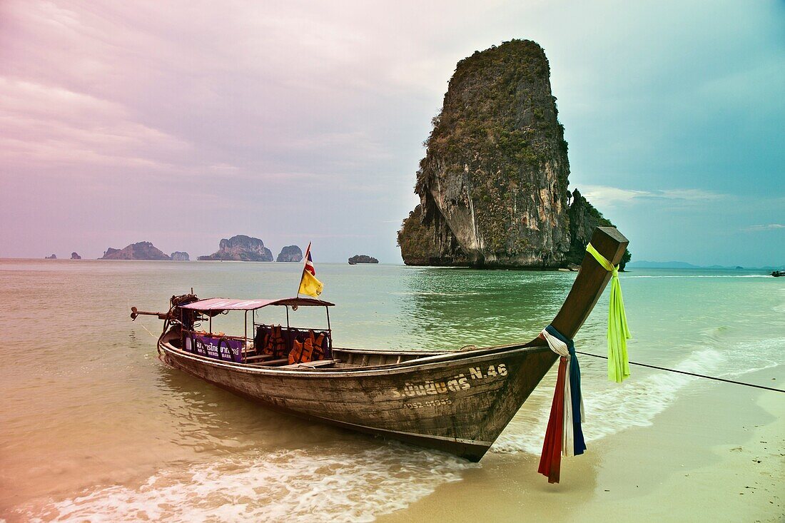 Rai Leh bay  Railay bay  Long-tail boat at the sandy Phranang Beach and limestone cliffs in the Andaman Sea Phranang Peninsula, Krabi province, Southern Thailand