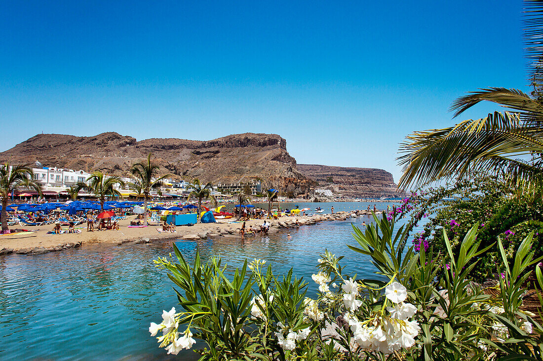 Menschen am Strand im Sonnenlicht, Puerto de Mogan, Gran Canaria, Kanarische Inseln, Spanien, Europa