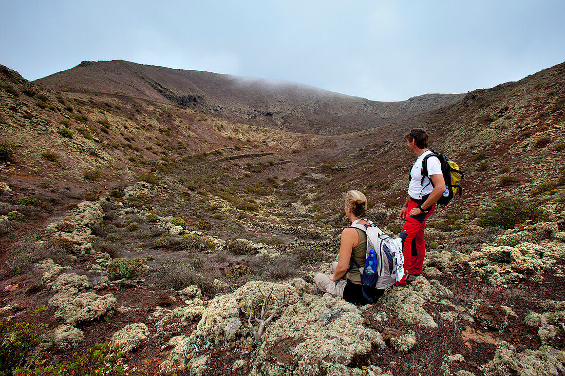 Hiker on top of volcan Los Helechos, Lanzarote, Canary Islands, Spain, Europe