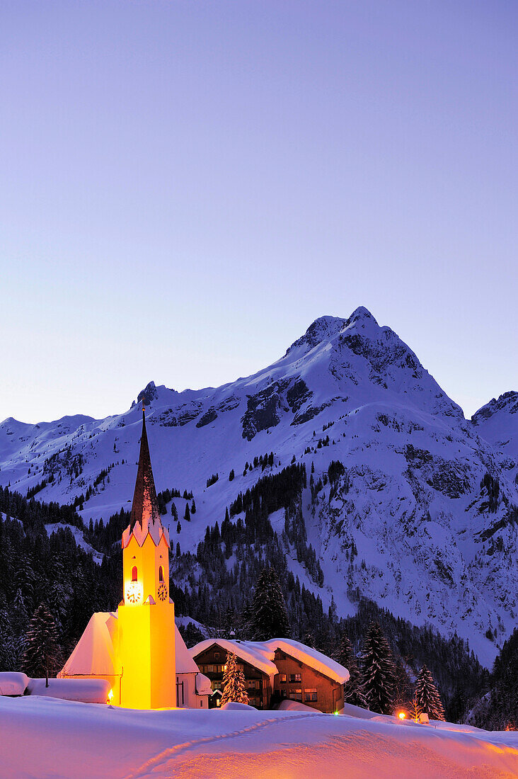 Beleuchtete Kirche vor Bergkulisse, Schröcken, Vorarlberg, Österreich