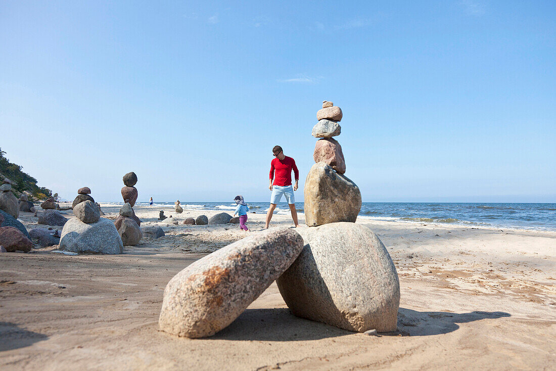 Vater und Sohn spielen am Strand neben Steinmännchen, Ostsee, MR, Bansin, Insel Usedom, Mecklenburg-Vorpommern, Deutschland