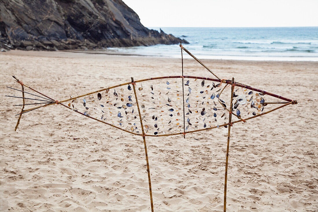 fish sculpture made of reed and mussels on the beach near Odeceixe, Atlantic Coast, Algarve, Portugal, Europe
