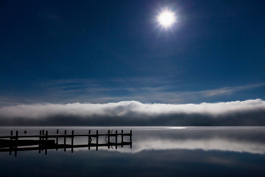 Moon over Lake Starnberg, pier and fog at dawn, Upper Bavaria, Germany