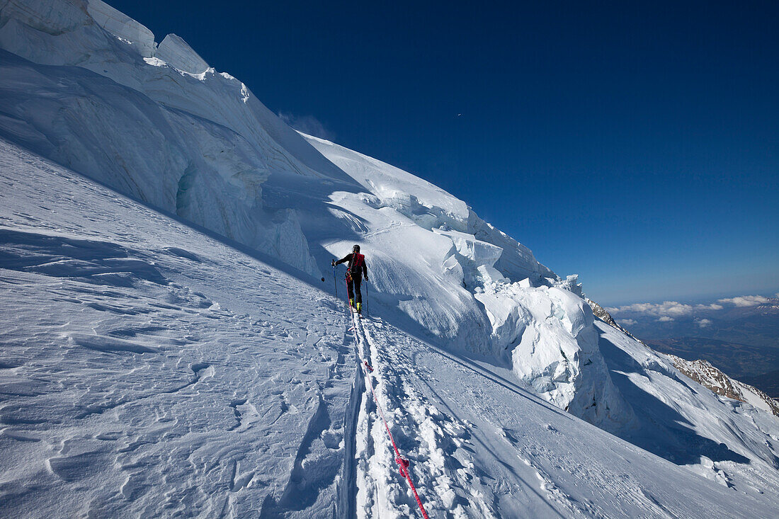 Ski mountaineer below an icefall, Mont Blanc du Tacul, Chamonix, Mont-Blanc, France
