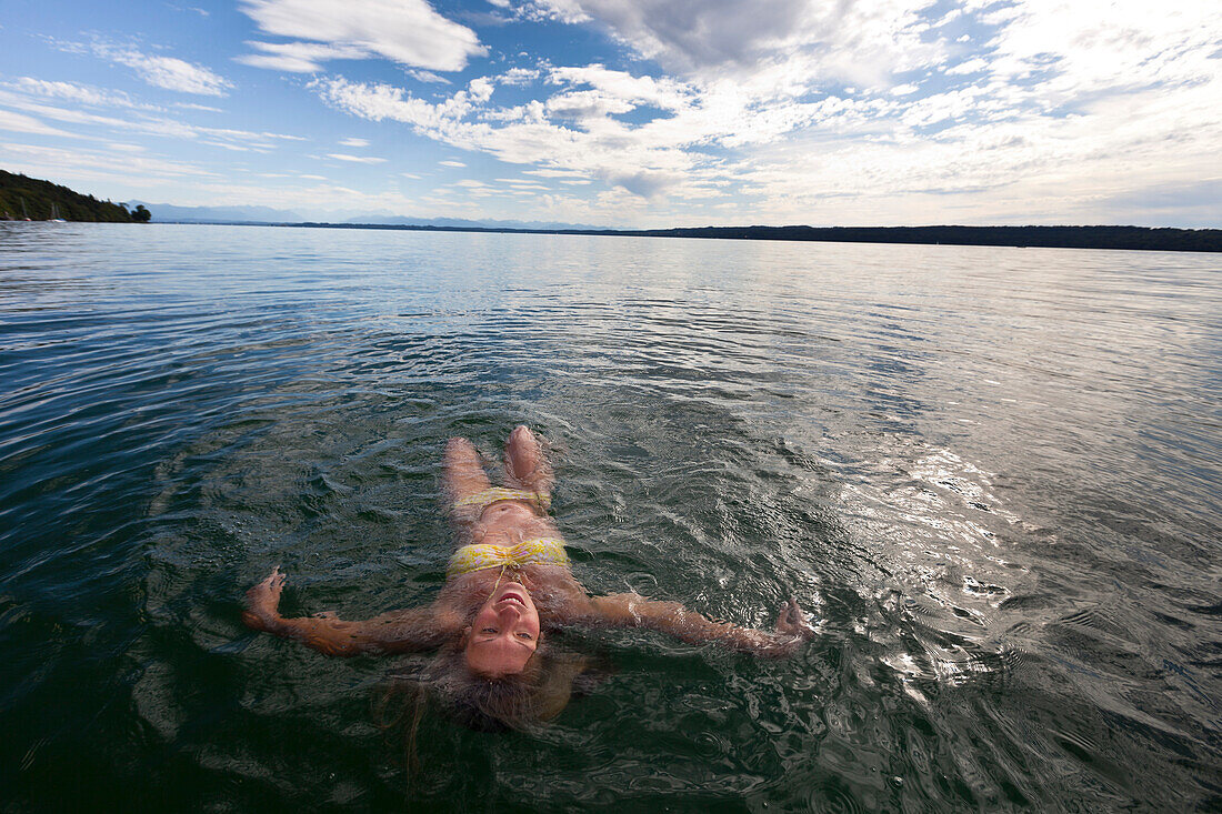 Junge Frau schwimmt in Starnberger See, Oberbayern, Deutschland