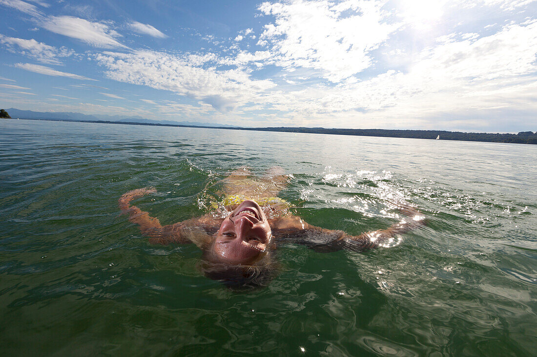 Junge Frau schwimmt in Starnberger See, Oberbayern, Deutschland