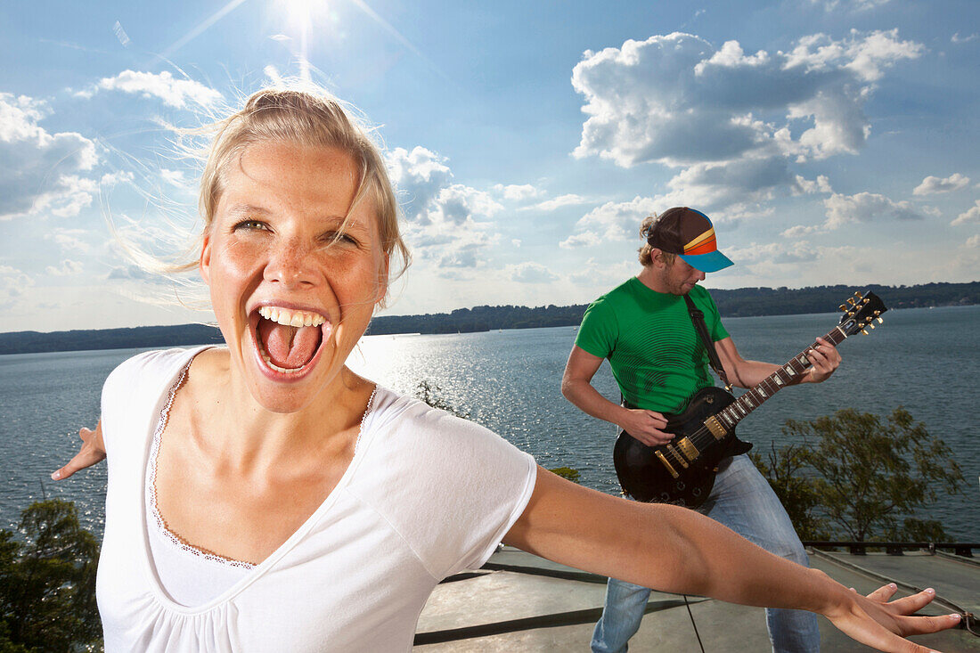 Junge Frau und Gitarrist über dem Starnberger See, Oberbayern, Deutschland