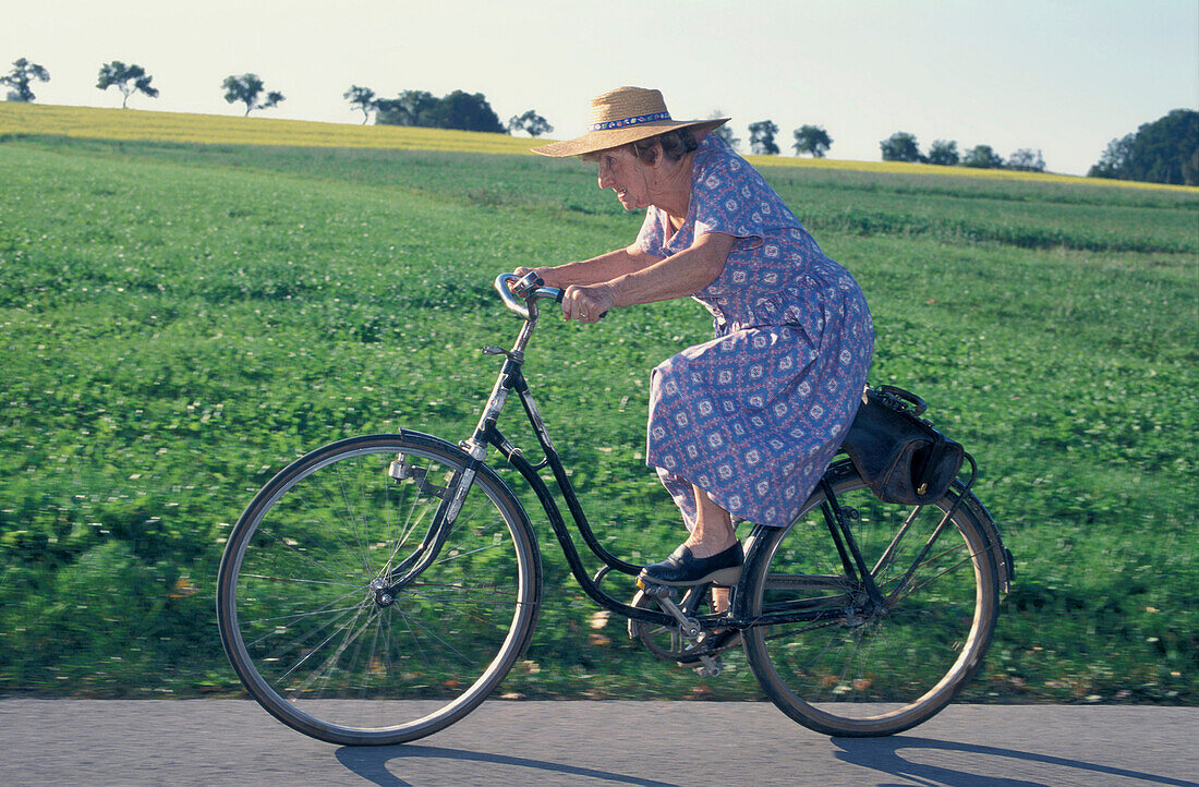 Elderly woman riding a bicycle, Upper Bavaria, Germany