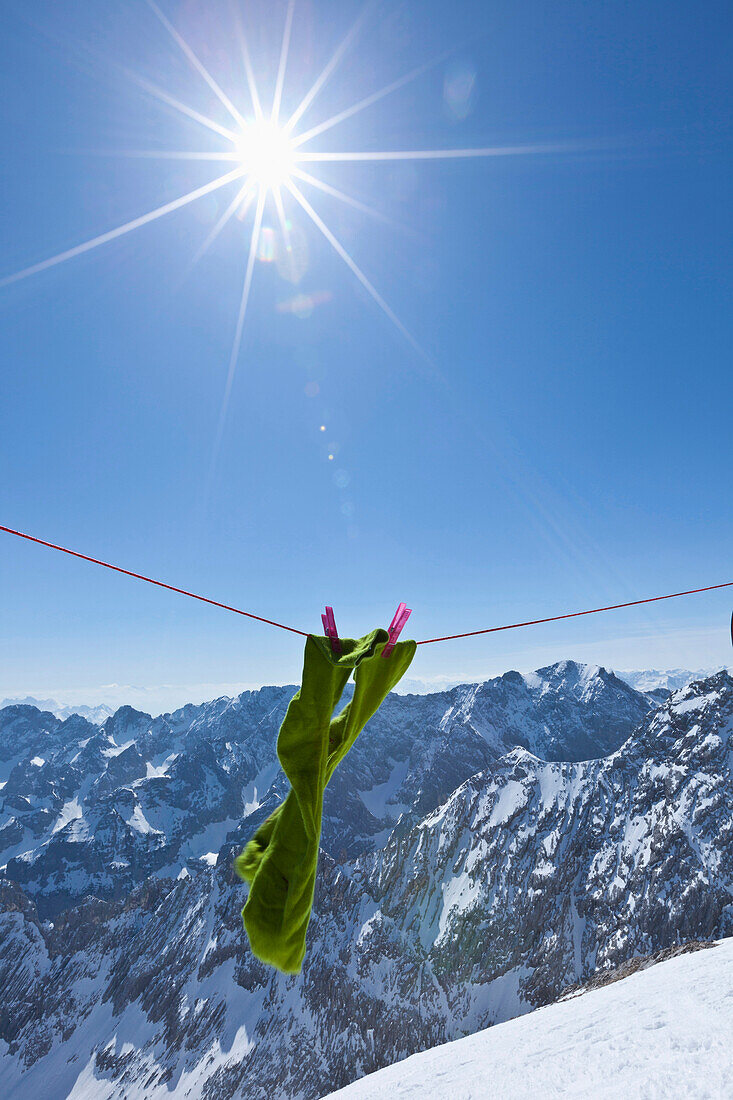 Green socks on clothesline in the sunlight, view onto Wetterstein and Karwendel mountains, Alpspitze, Alps, Bavaria, Germany, Europe