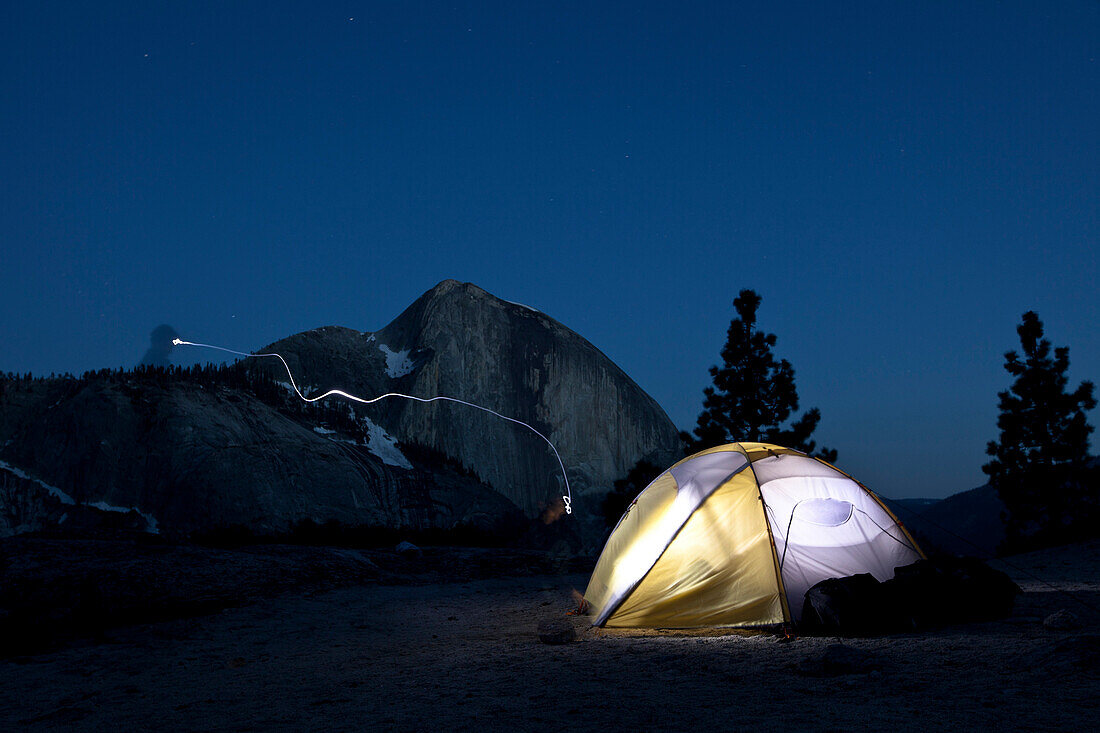 Headlamp amd lit tent in front of Half Dome at night, Yosemite National Park, California, USA, America
