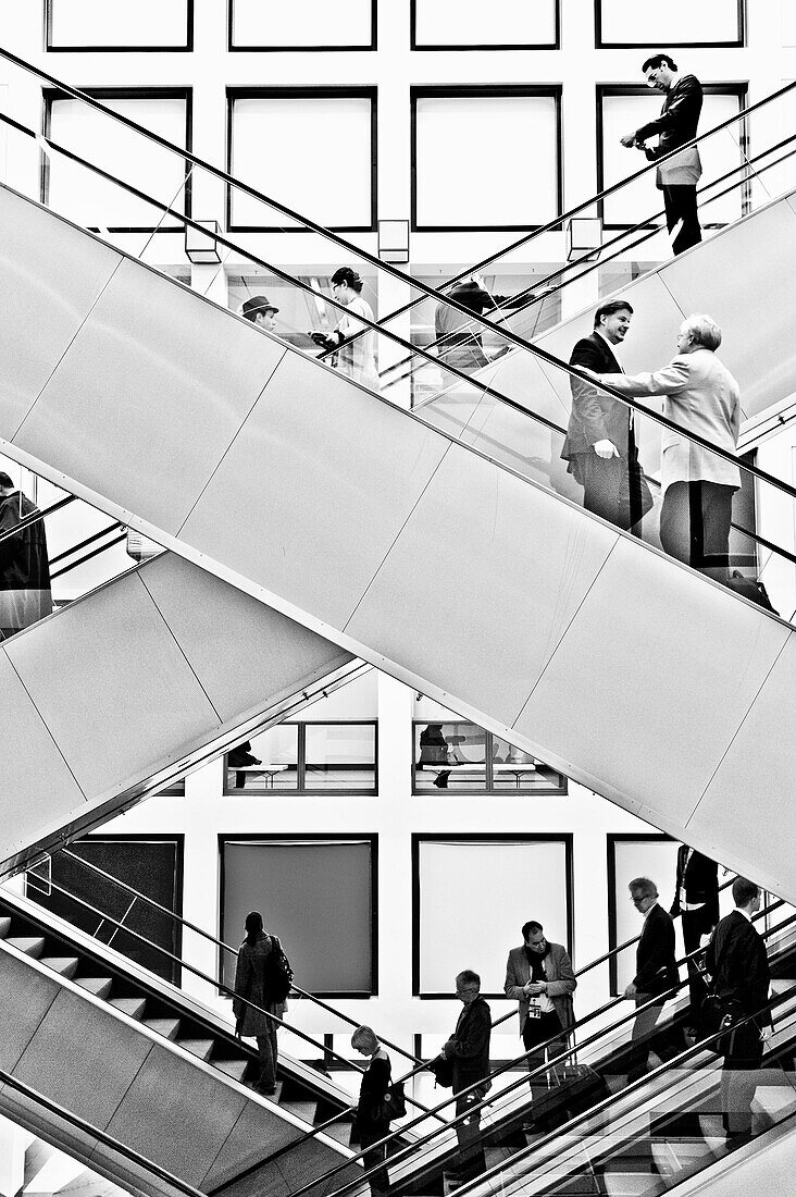 People, business people on escalators, Berlin Exhibition, Berlin, Germany