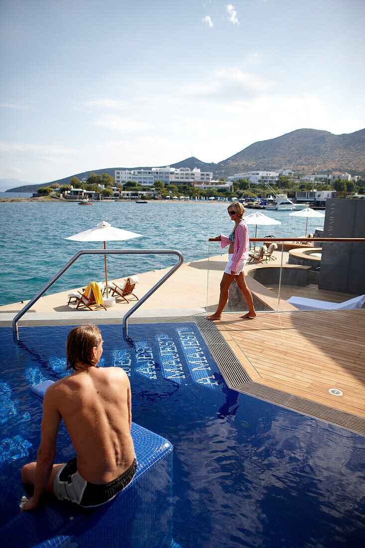 Mann und Frau am Pool und Deck der Yachting Club Villas, Elounda Beach Resort, Elounda, Kreta, Griechenland