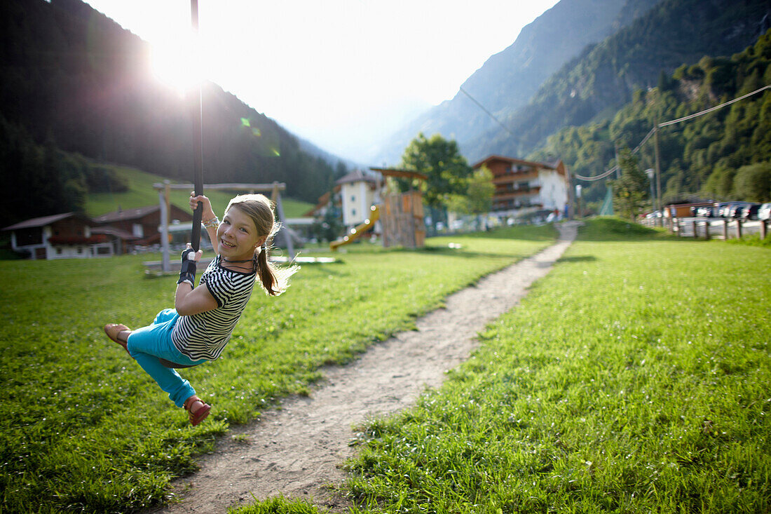 Mädchen spielt an der Seilbahn, Außenbereich des Hotel Feuerstein, Pflersch, Gossensaß, Südtirol, Italien