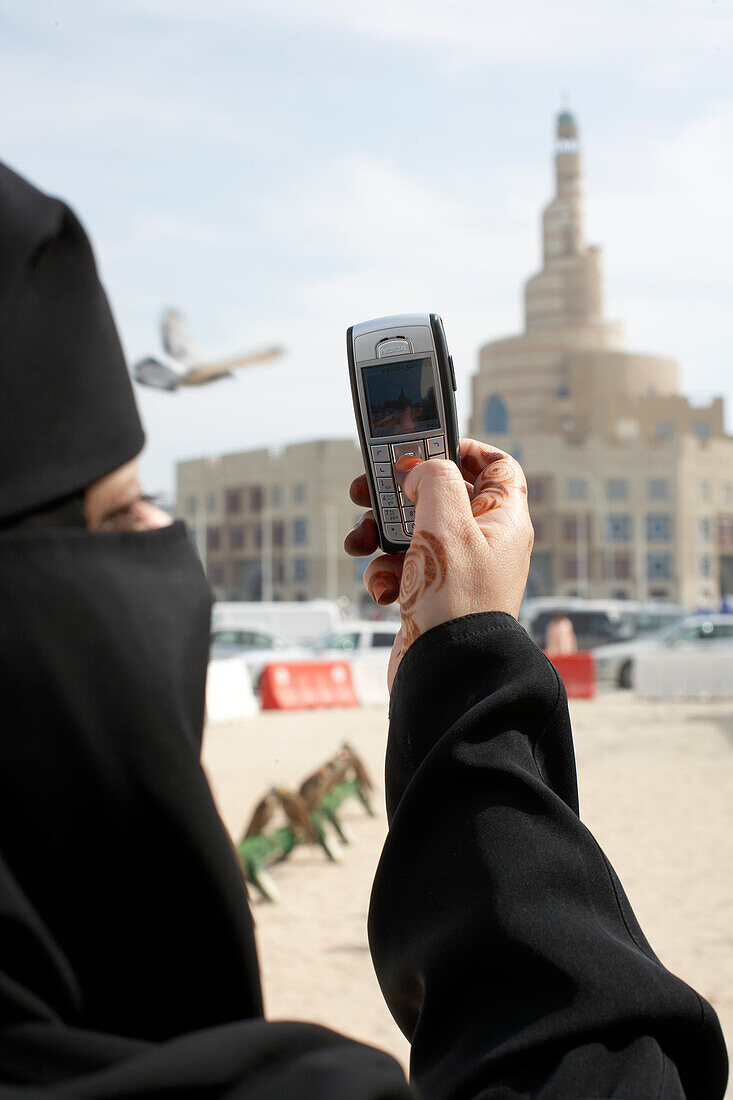 Woman photographing KDF Islamic Center with mobile phone, Doha, Qatar