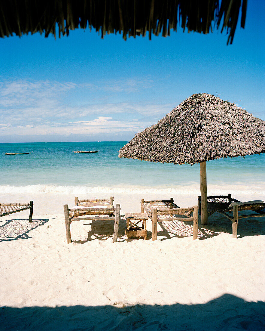 Sunshades and traditional beds made out of coconut ropes for guests, beach of Blue Oyster Hotel, Jambiani, south east Zanzibar, Tanzania, East Africa