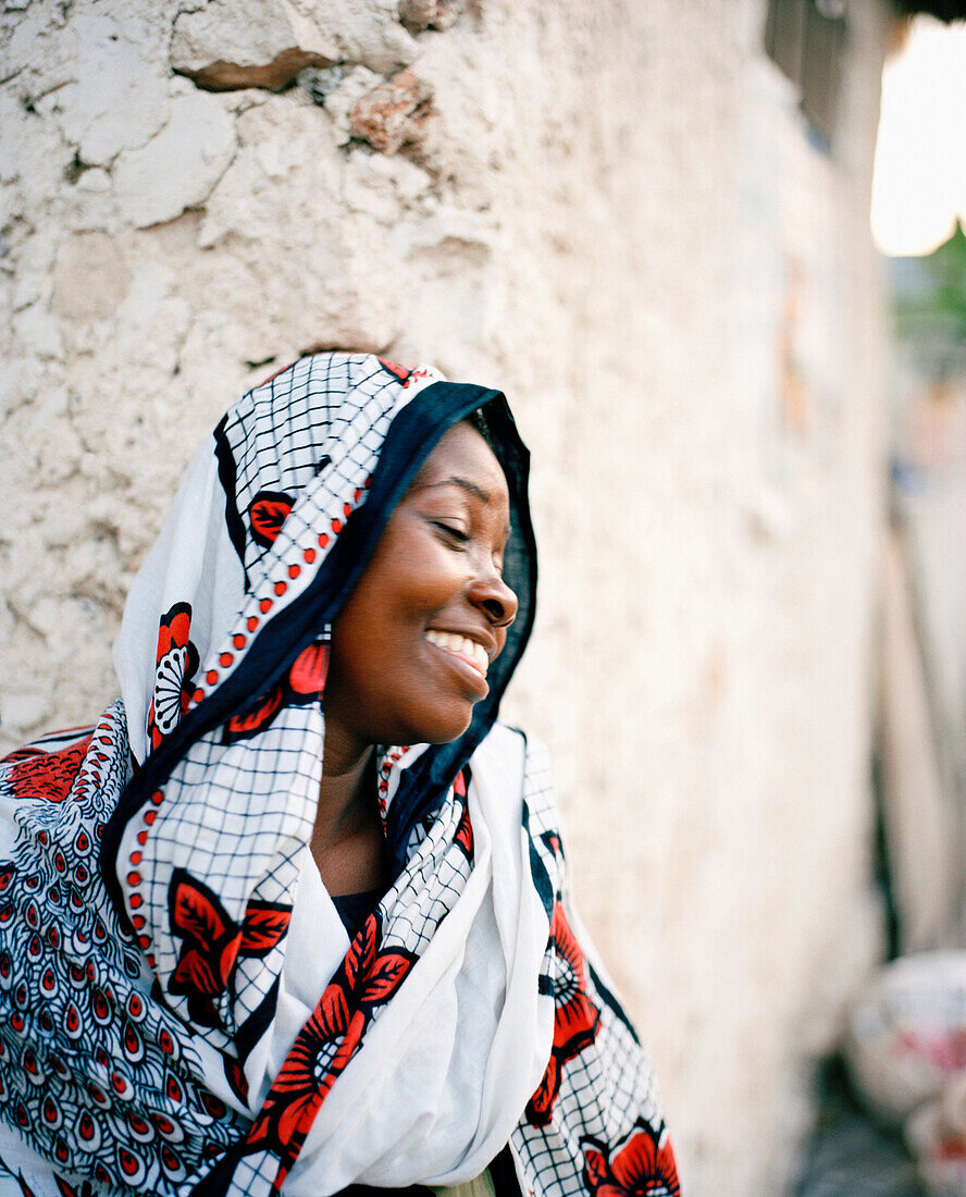 Frau im Kanga Tuch, am Versammlungshaus des Dorf Jambiani, Südostküste, Sansibar, Tansania, Ostafrika