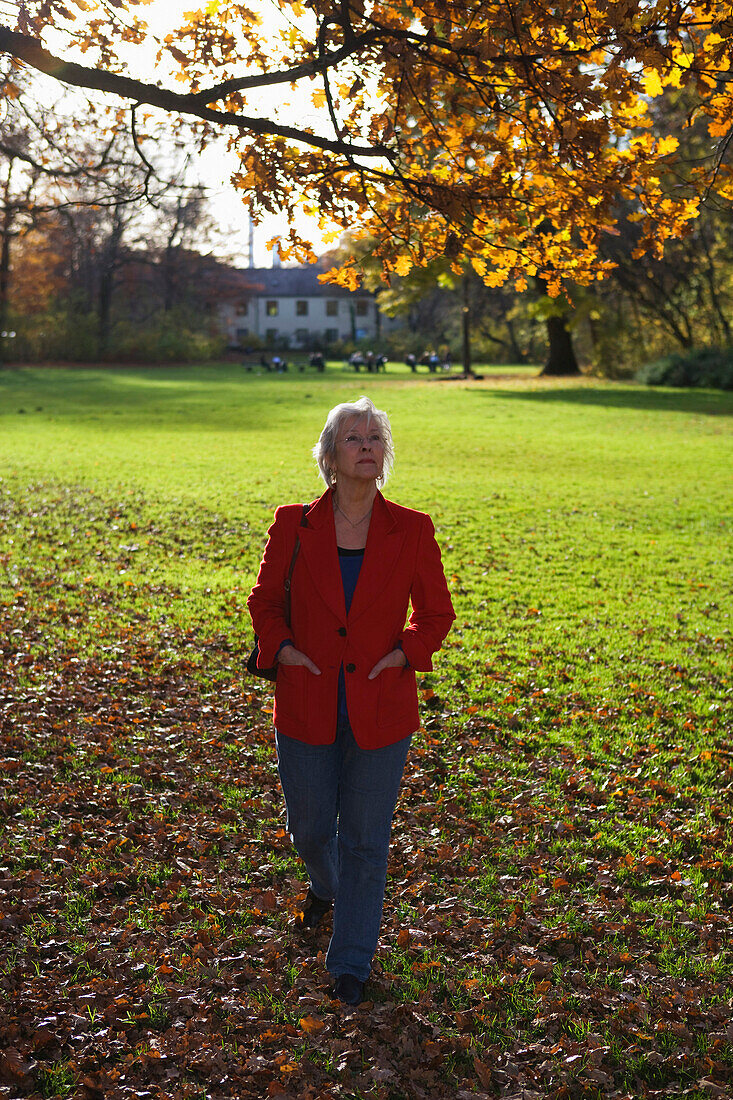 Rentnerin geniesst einen Herbsttag in den Isarauen, München, Oberbayern, Bayern, Deutschland, Europa