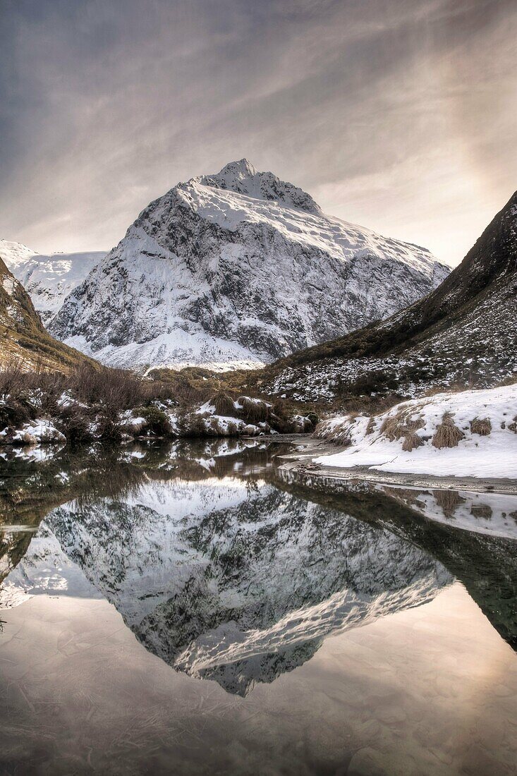 Mt Talbot, winter reflection with ice halo in sky, Hollyford valley, Fiordland National Park, World Heritage site