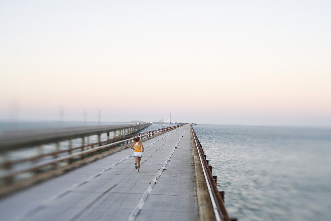 Woman Running on Bridge Over Ocean, Rear View, Florida Keys, USA