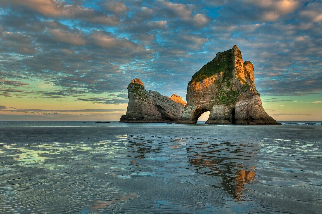 Archway Islands, sunrise lights up high clouds, Wharariki beach, near Collingwood, Golden bay