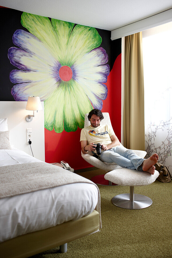 Man in a hotel room, flower fresco in background, Brussels, Belgium