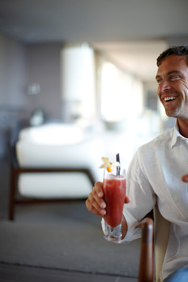 Man holding a cocktail in a hotel lounge, Ramatuelle, Provence-Alpes-Cote d'Azur, France