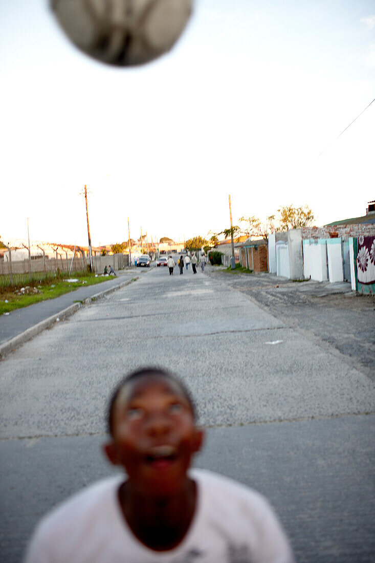 Junge mit Fußball auf der Straße vor Guguletu Township, Cape Flats, Kapstadt, Südafrika, Afrika