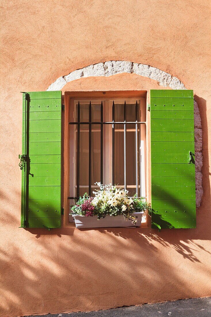 Close up of green window shutters with a flower box in Provence, France, Europe