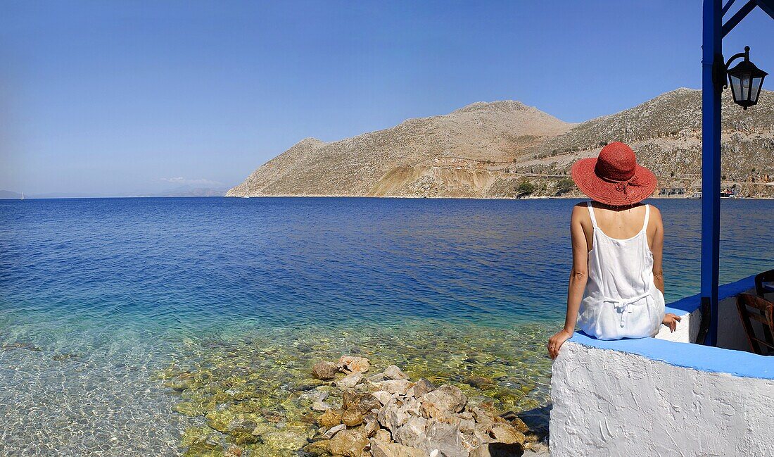 Woman admiring the sweeping view of the sea in the island town of Symi Greece