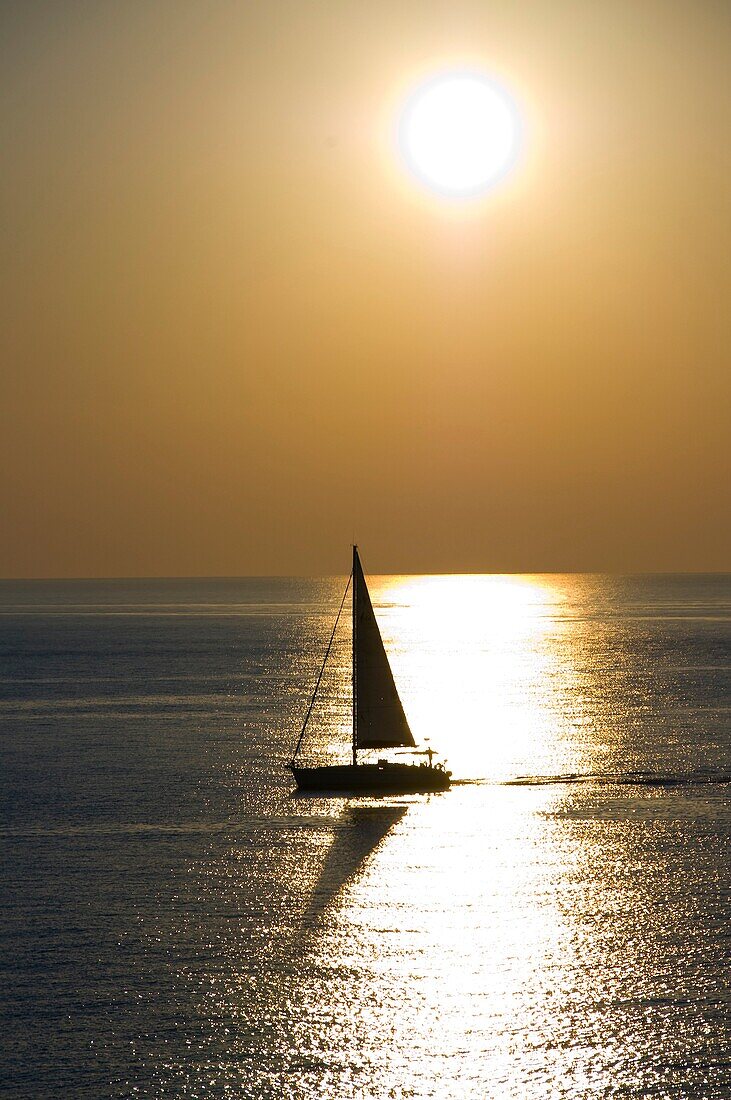 A sailboat navigating in the water with sunlight