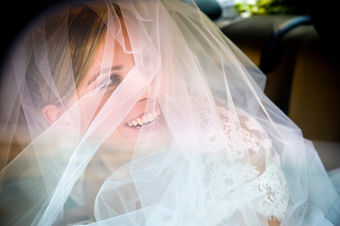 Bride in full wedding veil looking back and smiling