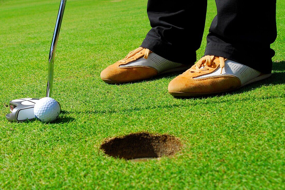 Close-up of Golfer Putting into Hole
